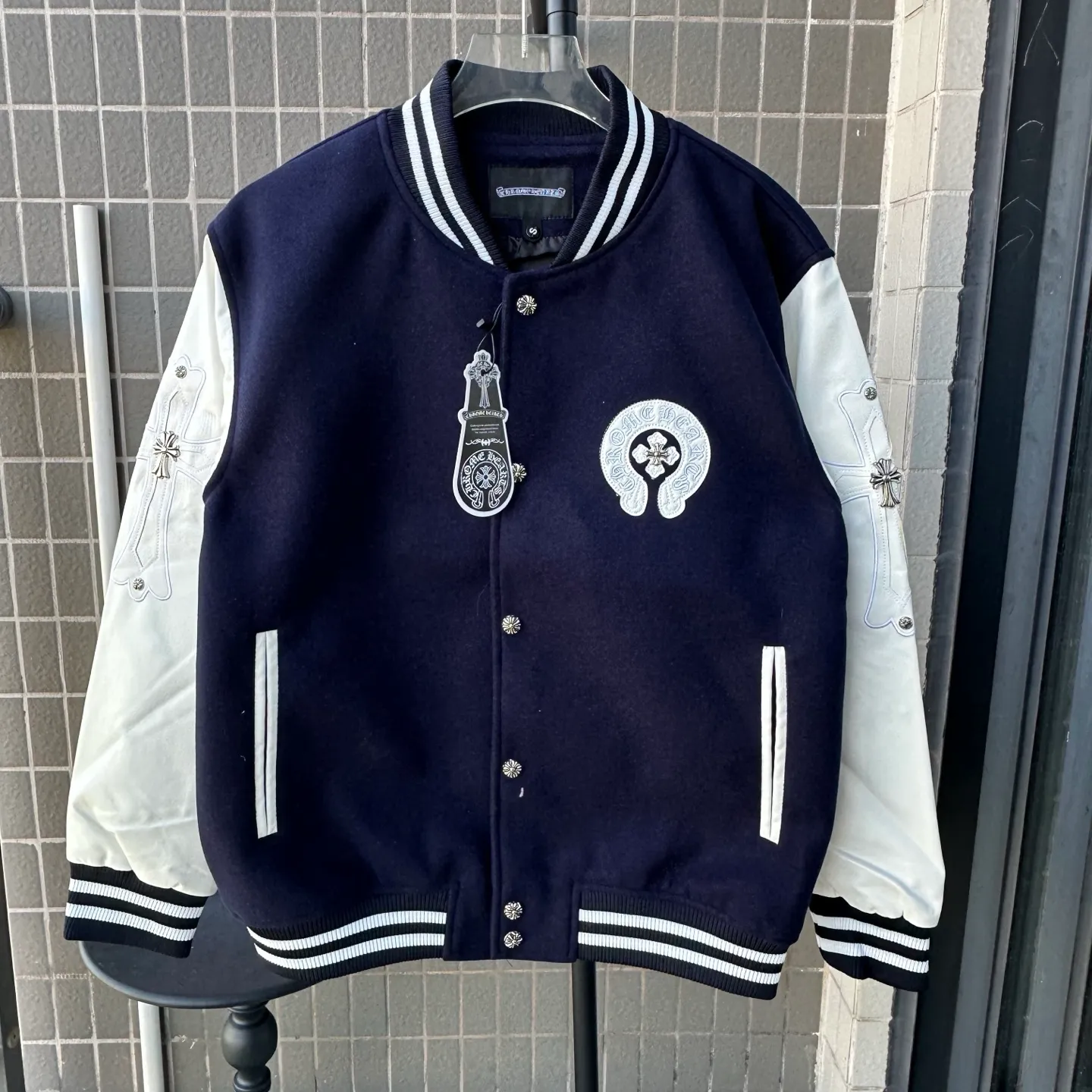 P370 Model No.: TT110 Chromehearts/Cro Heart Cross Embroidered Letters Leather Sleeves Spliced ​​Baseball Jacket Channel Boutique The most popular baseball jacket among fashionable men and fashionable women. There are versions at all levels in the market (you must compare the details). The most powerful quality control has been producing and researching baseball uniforms for 7 years. The details are exquisite. With it, you are the most beautiful boy in the world. The paint-coated full-face four-button buckle (button with LOGO), the average weight of the fabric is nearly 900 grams, and it is made of wool + eyeliner blended, custom-woven and dyed wool with high color fastness. The lining is made of silky and delicate cupro fiber! The texture is thick, the color is more uniform and beautiful, and the sharp edges and corners are full of three-dimensionality, showing laziness, casualness, and youthful vitality! Color: Black Navy Size: S-XL